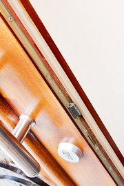 Moderne Isolierung und Sicherheitsbeschläge zur Erhaltung einer Haustüre aus Massivholz.
